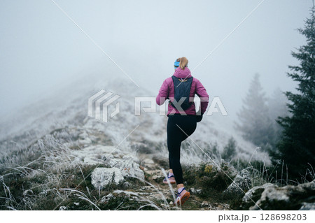 Trail Runner in Misty Mountain Landscape Trail Runner in Misty Mountain Landscape 128698203