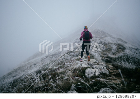Trail Runner in Misty Mountain Landscape 128698207