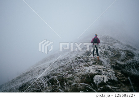 Trail Runner in Misty Mountain Landscape 128698227