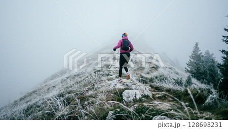 Trail Runner in Misty Mountain Landscape 128698231