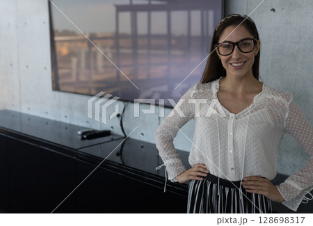 Smiling woman wearing glasses in modern office environment, feeling confident, copy space Smiling woman wearing glasses in modern office environment, feeling confident, copy space 128698317