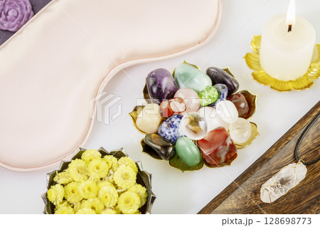 Relaxing ritual with crystals gemstones set, candle and sleep mask on white background. Esoteric spiritual practice, Healing Crystal Ritual, Relax Chakra. Relaxing at home and self care concept 128698773