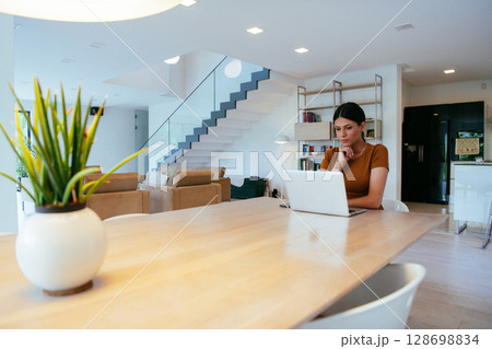 Woman sitting in living room using laptop looking at cam talk by video call with business friend relatives, head shot. Job interview answering questions 128698834