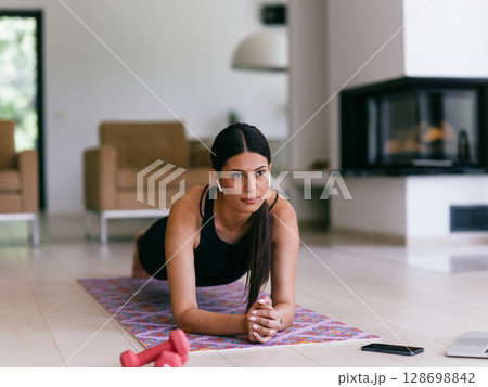 Young woman resting after online training while lying on the living room floor. Young woman resting after online training while lying on the living room floor. 128698842