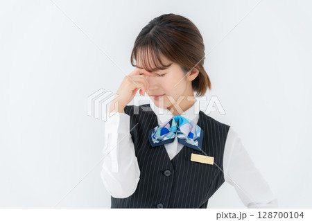 制服の若い女性　ビジネス　眼精疲労 128700104