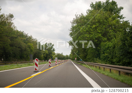 Traffic barriers and lane markings on rural highway during road construction in summer 128700215