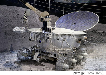 Moon rover on display at museum showcases engineering and technological achievements. Detailed design shows wheels, solar panels, and communication devices 128700286