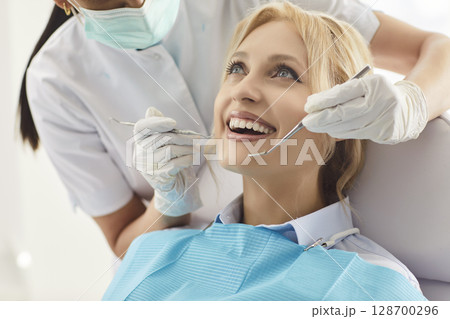Doctor Examining Woman Patient Oral Care In Clinic 128700296
