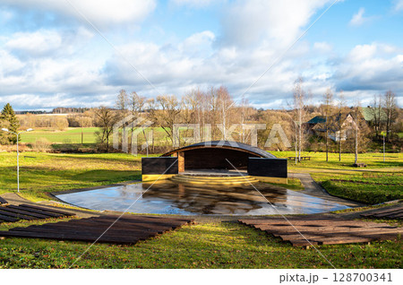 Empty open air stage in a park, with a sound projecting roof 128700341