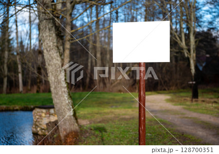 Empty blank sign board on a pole in a park 128700351