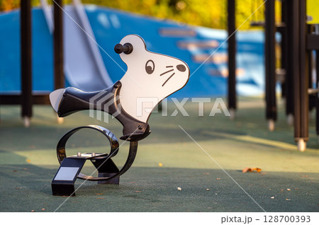 swing for children on a kids playground, swing mouse toy for kids on a childrens playground 128700393