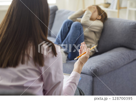 Psychologist trying to help a little child boy with his fears during therapy session. 128700395