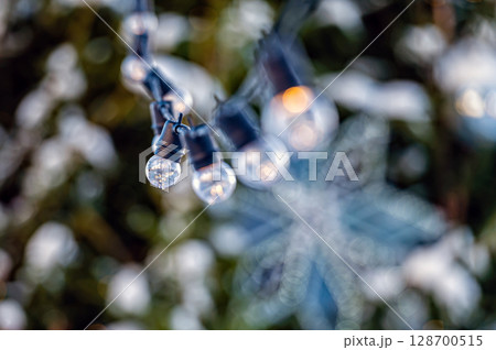 garland of light bulbs on defocused festive lights background, shallow depth of field, copy space garland of light bulbs on defocused festive lights background, shallow depth of field, copy space 128700515