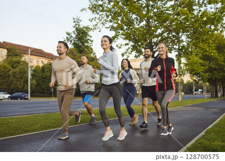 People running together along road, dressed in sportswear, having morning workout, sporty lifestyle 128700575