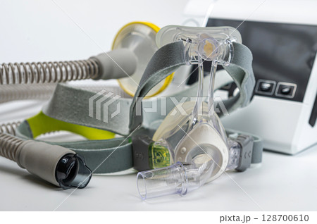 Continuous positive airway pressure system includes of CPAP machine, mask, tube on white background. 128700610