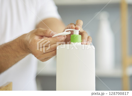 Using cleansing lotion in daily bathroom routine for clean skin of man, hands press dispenser 128700817