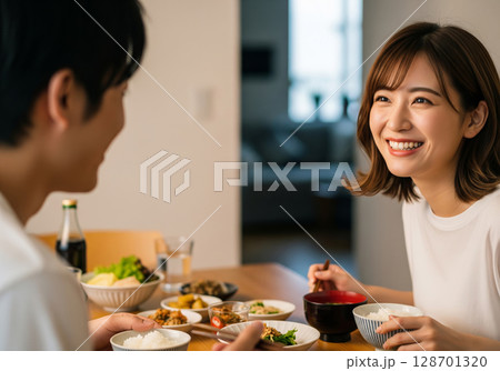 食卓で弾む会話と笑顔！白Tシャツで過ごす夫婦の幸せなひととき 128701320