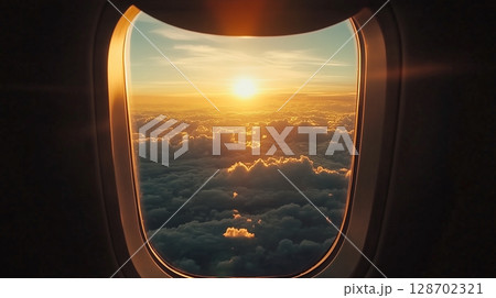 Plane window capturing breathtaking orange beauty view sunset from journey 128702321