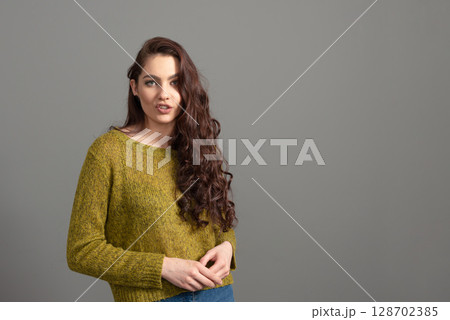 portrait of beautiful sensual woman with long curly hair against gray background portrait of beautiful sensual woman with long curly hair against gray background 128702385