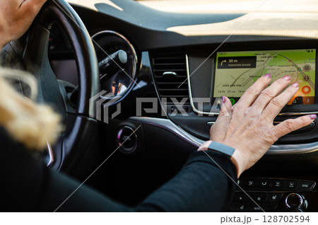 middle aged woman using car navigation system 128702594