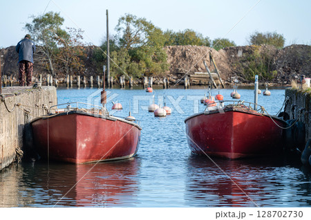 fishing boats docked in the harbor channel 128702730