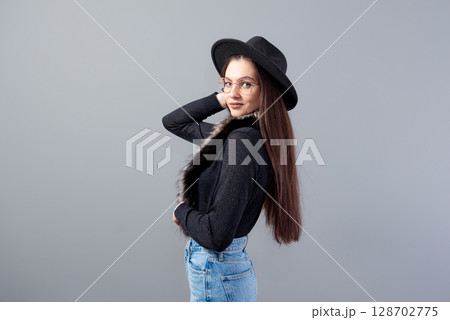 portrait of a sensual woman with long hair and a black hat on her head isolated on a gray background portrait of a sensual woman with long hair and a black hat on her head isolated on a gray background 128702775