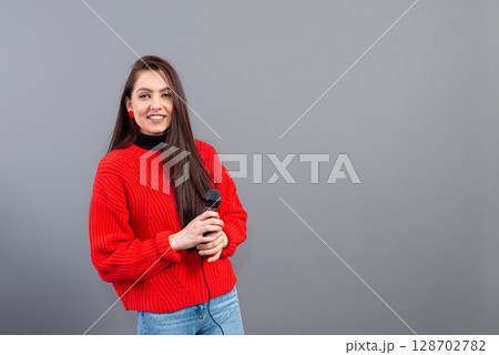female conference speaker dressed in a red sweater during presentation calling for attention, isolated female conference speaker dressed in a red sweater during presentation calling for attention, isolated 128702782