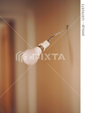 Vintage hanging light bulb over gray background  128702873