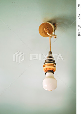 Vintage hanging light bulb over gray background  128702876