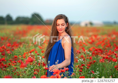 portrait of elegant young woman in poppy field in evening sunlight portrait of elegant young woman in poppy field in evening sunlight 128703257