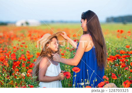 elegant young woman with child girl in poppy field, happy family having fun in nature, summer time 128703325