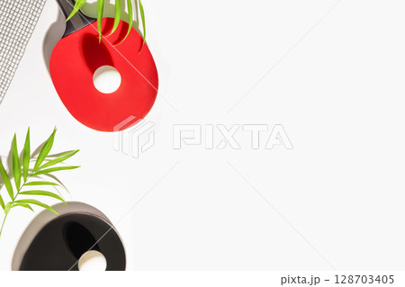 Table tennis, ping-pong. Sport composition with rackets, balls, net and palm leaves on white background with copy space. The concept of table tennis competitions. Flat lay 128703405