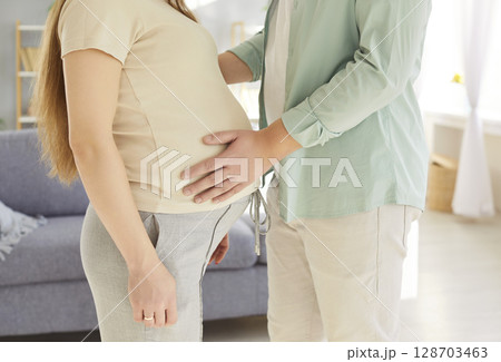 Loving careful supportive husband tenderly touching the belly of his pregnant wife Loving careful supportive husband tenderly touching the belly of his pregnant wife 128703463
