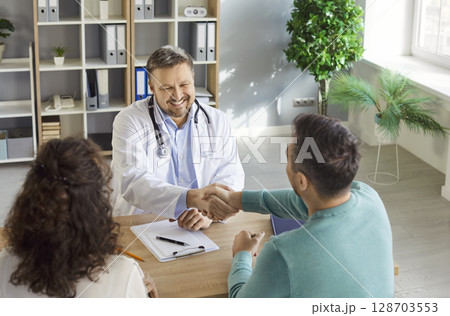 Doctor meets, agrees, congratulating patients in clinic centre, consulting family couple, counseling 128703553
