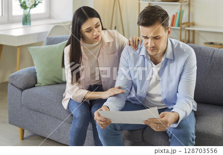 Frustrated desperate man checking bills for payments, holding health test result, getting upset Frustrated desperate man checking bills for payments, holding health test result, getting upset 128703556