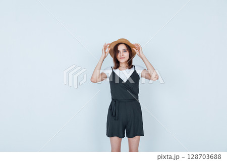 brunette woman in sherts and straw hat on white background 128703688
