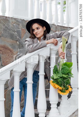 Beautiful fashion brunette woman wearing a hat with orange sunflowers Beautiful fashion brunette woman wearing a hat with orange sunflowers 128703700