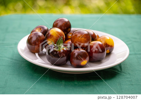 fresh cherry tomatoes of different varieties on a plate on the blurred background, closeup fresh cherry tomatoes of different varieties on a plate on the blurred background, closeup 128704007