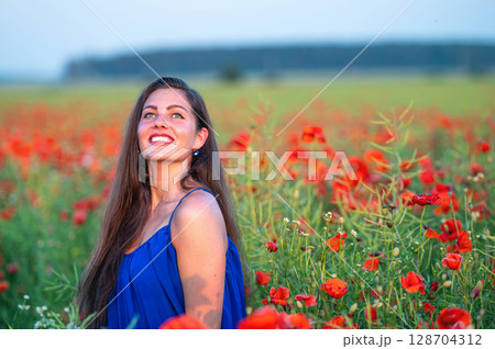 portrait of elegant young woman in poppy field in evening sunlight portrait of elegant young woman in poppy field in evening sunlight 128704312