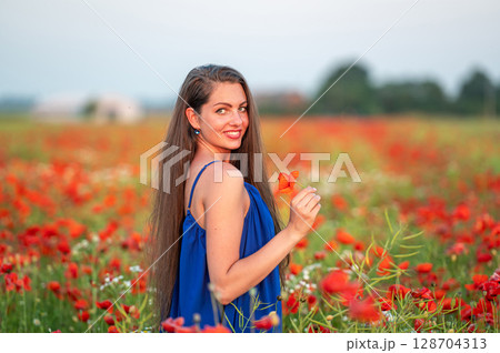 portrait of elegant young woman in poppy field in evening sunlight portrait of elegant young woman in poppy field in evening sunlight 128704313