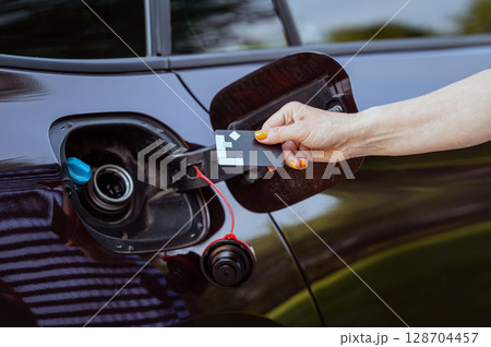 female with credit card in front of open gas tank, fuel price rise concept, hands closeup female with credit card in front of open gas tank, fuel price rise concept, hands closeup 128704457