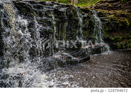 beautiful view in spring of a waterfall on small river Ivande in Latvia 128704672