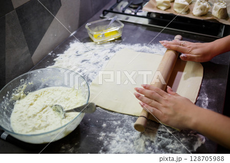 Baking domestic rolls with cheese. Putting cheese on dough for rolls 128705988