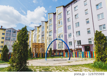 New residential high-rise buildings. Apartments with balconies in a new area. Modern residential buildings. Children's playground in the courtyard of a residential building. 128705989