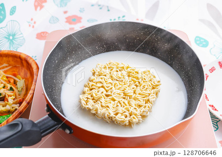 鍋で牛乳と水でインスタントラーメンを茹でる 鍋で牛乳と水でインスタントラーメンを茹でる 128706646