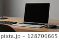 Modern laptop computer on a light wooden desk with keyboard and mouse. 128706665