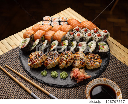 Assorted sushi arranged on a slate platter 128707267