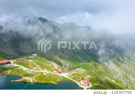 romania travel landscape with road pass. green valley of fagaras mountains. dramatic scenery of transylvania. beautiful view above alpine lake balea in summer. scenic landmark of europe 128707750