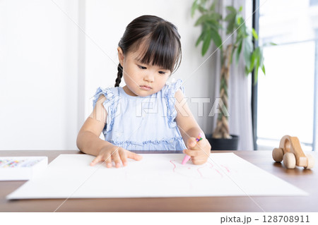 クレヨンでお絵描きを楽しむ女の子の知育シーン 128708911