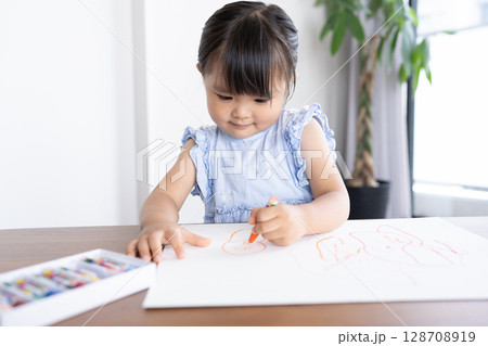 クレヨンでお絵描きを楽しむ女の子の知育シーン 128708919
